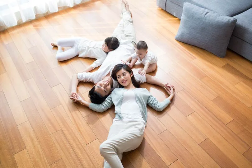 Happy young family resting on wooden floor, this could be you if read our blog dang it.